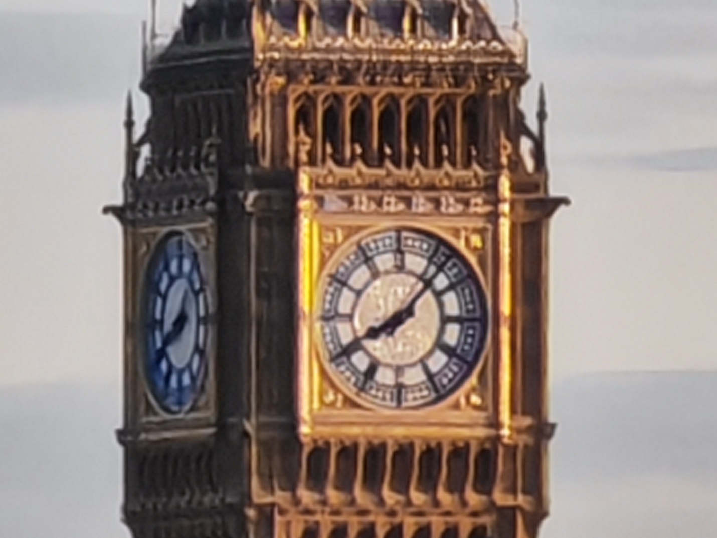 A clock tower with a large clock on it with Big Ben in the background

Description automatically generated