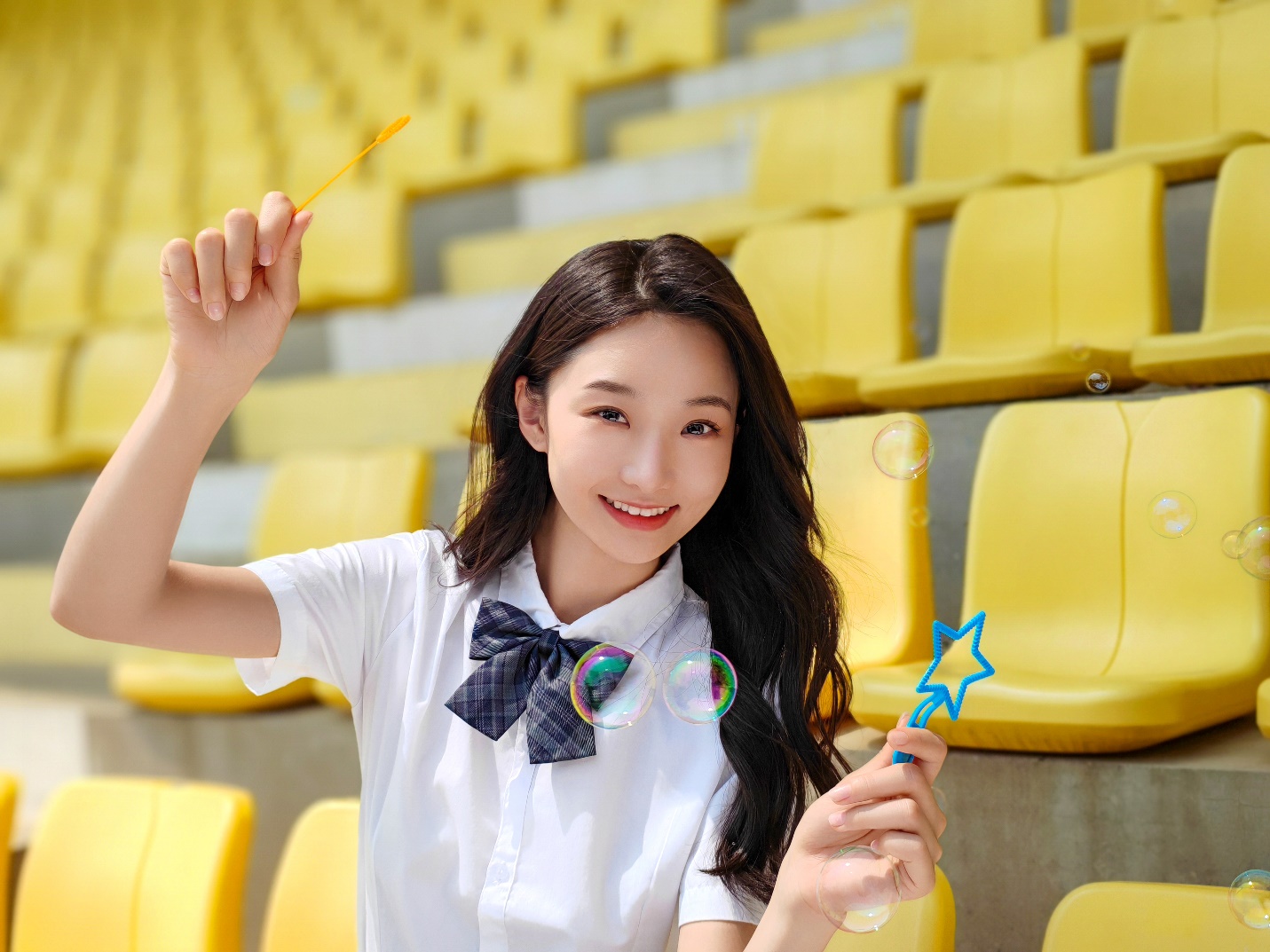 A person holding a wand in front of a yellow seat

Description automatically generated