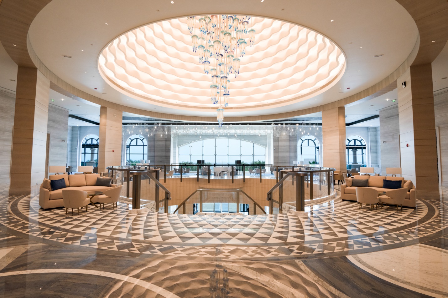 A large room with a chandelier and a large ceiling

Description automatically generated